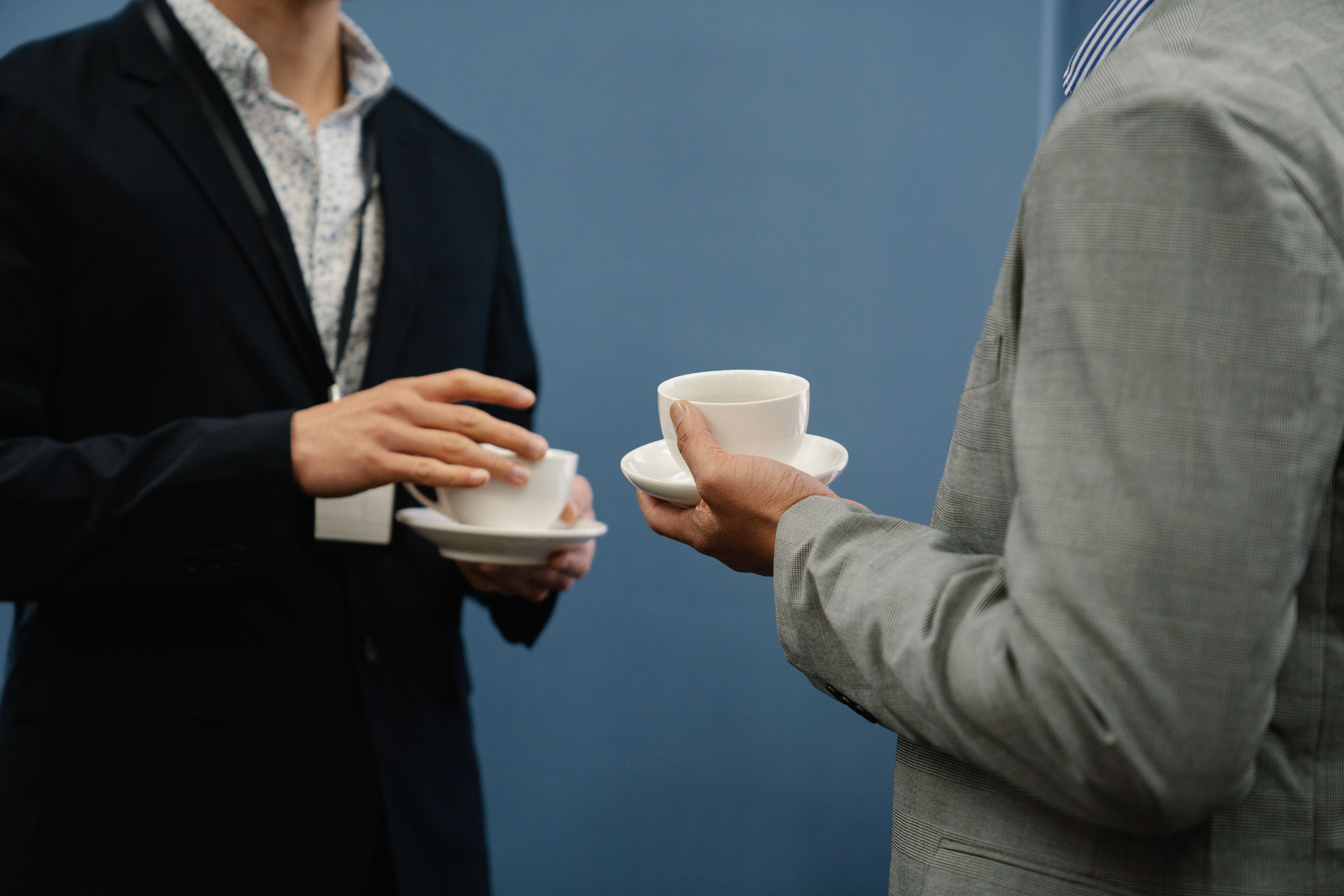 Two business professionals holding coffee during a casual, genuine meeting that builds rapport and trust