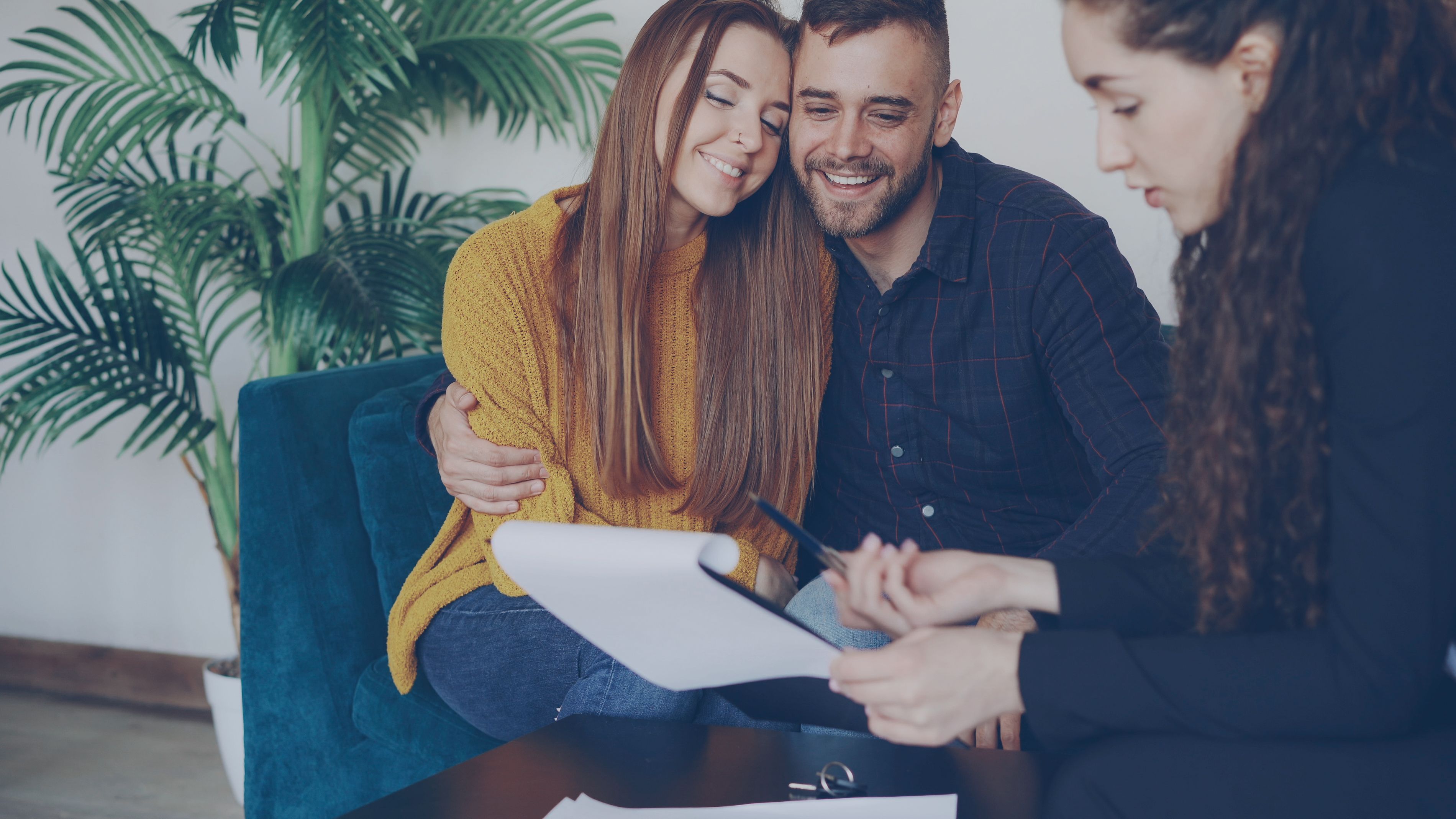 Smiling couple consulting with a trustworthy adviser in a warm office setting