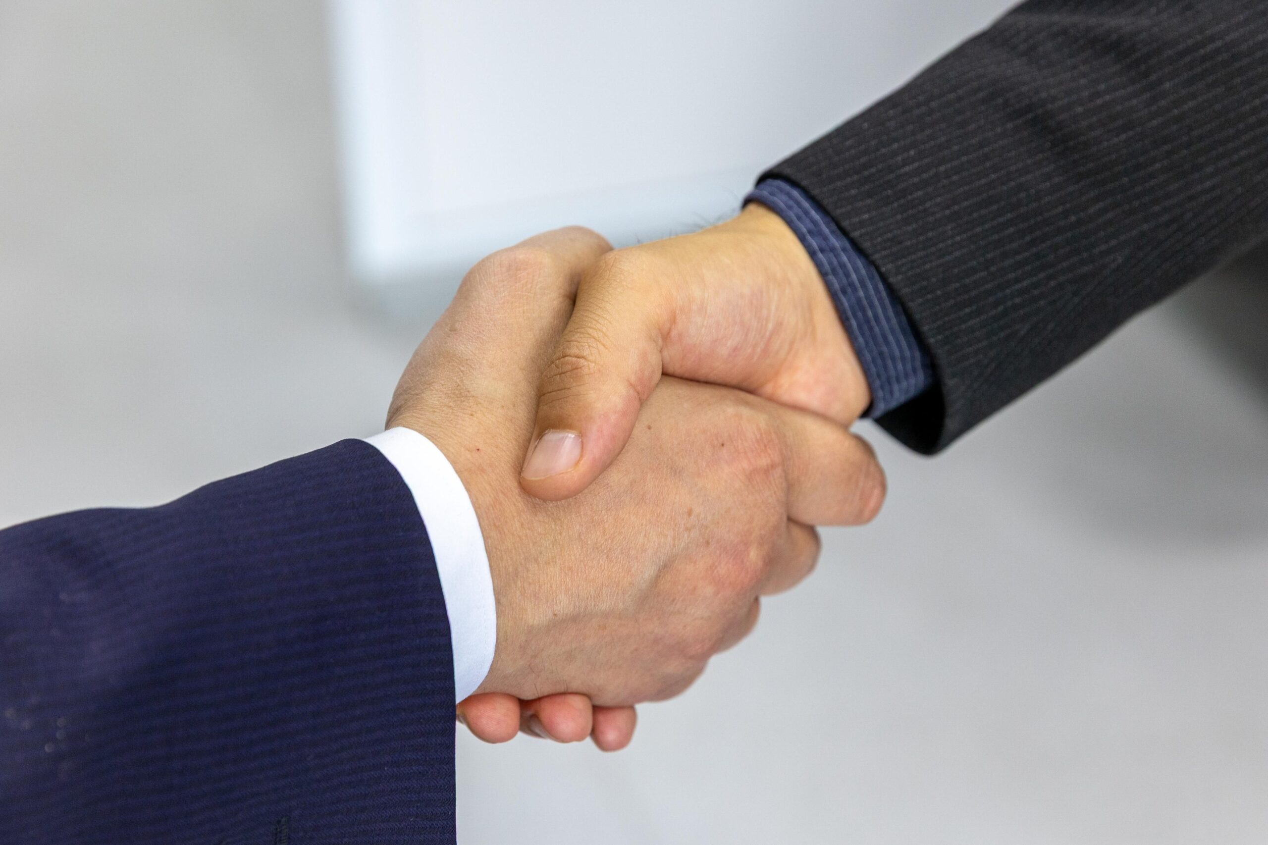 Two professionals shaking hands in a business meeting, symbolizing trust and partnership built on authenticity