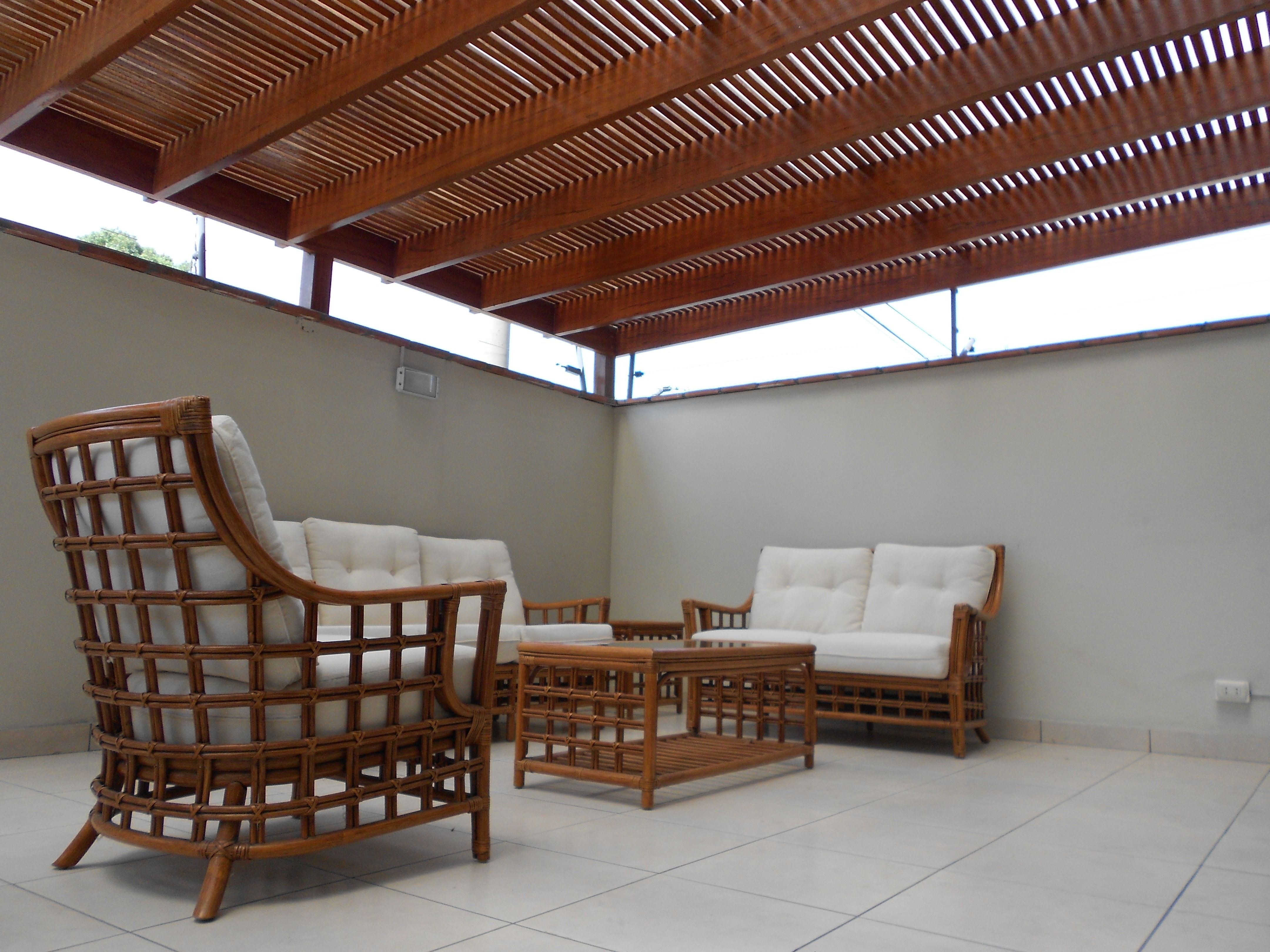 Comfortable outdoor patio with rattan chairs beneath a wooden pergola, illustrating a useful outdoor living upgrade.